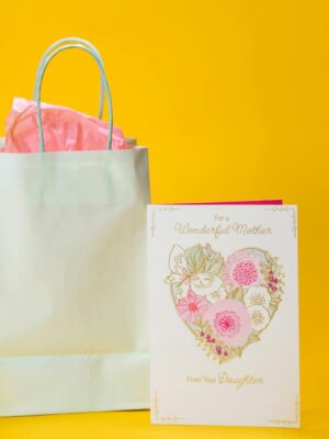 A beautifully designed Mother's Day card and gift bag on a vibrant yellow background, perfect for celebrating a special occasion.