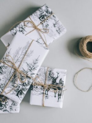 Elegant gift boxes wrapped in nature-themed paper with twine, perfect for any festive occasion.