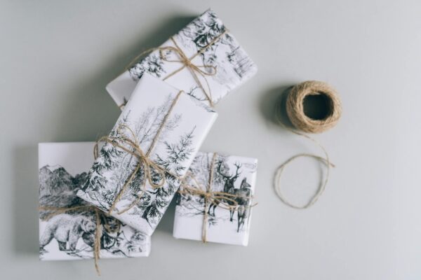 Elegant gift boxes wrapped in nature-themed paper with twine, perfect for any festive occasion.