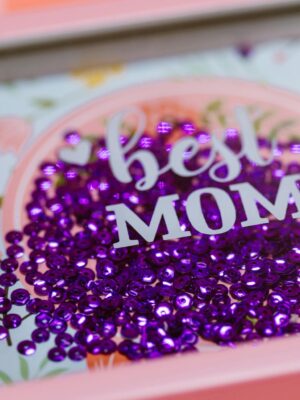 Vibrant 'Best Mom' shadow box with purple sequins, ideal gift for Mother's Day.