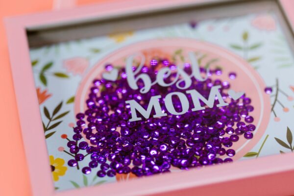 Vibrant 'Best Mom' shadow box with purple sequins, ideal gift for Mother's Day.